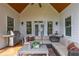 Inviting covered deck with stainless grill, comfortable seating, and outdoor lighting at 100 Ashley Hall Ct, Woodstock, GA 30188