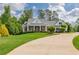 Charming home with a manicured lawn and a circular driveway, lush landscaping, and inviting entryway at 100 Ashley Hall Ct, Woodstock, GA 30188