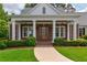 Welcoming entryway with stately columns and a beautifully landscaped walkway leading to the front door at 100 Ashley Hall Ct, Woodstock, GA 30188