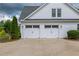 A two-car garage features white doors with black hardware and is attached to a white house at 100 Ashley Hall Ct, Woodstock, GA 30188