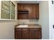 This laundry room features granite countertops, dark wood cabinets, and a sink at 100 Ashley Hall Ct, Woodstock, GA 30188