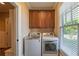 Functional laundry room featuring modern appliances, cabinet storage, and natural light, making chores a breeze at 100 Ashley Hall Ct, Woodstock, GA 30188