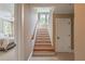 Carpeted staircase with wooden treads, white risers, and a view into a bedroom at 100 Ashley Hall Ct, Woodstock, GA 30188