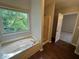 Bright bathroom featuring a soaking tub beneath a large window and separate shower at 1048 Brandon Ln, Stone Mountain, GA 30083