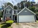 Charming two-story home featuring a gray facade, white garage door, and neatly manicured front yard at 1048 Brandon Ln, Stone Mountain, GA 30083