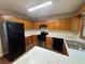 Functional kitchen with oak cabinets, black appliances, and marble-look countertops at 1048 Brandon Ln, Stone Mountain, GA 30083