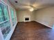 Open living room with fireplace, wood floors, large windows, and ceiling fan at 1048 Brandon Ln, Stone Mountain, GA 30083