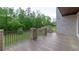 Expansive backyard view from patio; iron railings and manicured lawn meet a treeline backdrop at 10765 Shallowford Rd, Roswell, GA 30075