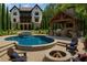 Stunning backyard featuring a pool, jacuzzi, fire pit, outdoor kitchen, and a covered patio with a fireplace at 10765 Shallowford Rd, Roswell, GA 30075