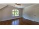 Cozy bedroom offers natural light from a large arched window, hardwood floors, and neutral paint at 10765 Shallowford Rd, Roswell, GA 30075