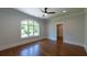 Spacious bedroom with hardwood floors, large arched window, recessed lighting, and white trim at 10765 Shallowford Rd, Roswell, GA 30075