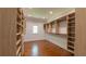 Walk-in closet with custom wood shelving and hardwood floors, offering ample storage and organization space at 10765 Shallowford Rd, Roswell, GA 30075