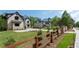 An exterior view showing a property with multiple houses and manicured lawn behind a fence at 10765 Shallowford Rd, Roswell, GA 30075
