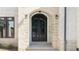 A close up of the elegant iron-wrought front door and stone facade of a residence at 10765 Shallowford Rd, Roswell, GA 30075