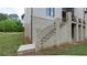 Exterior view with stone steps, iron railing, and white brick accents, surrounded by a lush green lawn at 10765 Shallowford Rd, Roswell, GA 30075