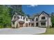 An exterior view showcasing the home's brick facade, multiple garages, and extensive driveway at 10765 Shallowford Rd, Roswell, GA 30075