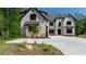 An exterior view of a home with a white facade, black trim, and meticulously landscaped front yard at 10765 Shallowford Rd, Roswell, GA 30075