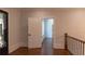 Entry foyer featuring hardwood floors, an ornate iron door, and access to a separate hallway through an open doorway at 10765 Shallowford Rd, Roswell, GA 30075