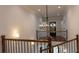 Hallway with chandelier and staircase featuring iron spindles and wood railing at 10765 Shallowford Rd, Roswell, GA 30075