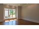 Sunlit living room with hardwood floors and a large window offering a view of the lush yard at 10765 Shallowford Rd, Roswell, GA 30075