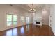 Open living room with fireplace, hardwood floors, tray ceiling, and balcony access through large windows at 10765 Shallowford Rd, Roswell, GA 30075