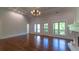 Bright living room features hardwood floors, tray ceilings, a fireplace, and balcony access through multiple windows at 10765 Shallowford Rd, Roswell, GA 30075
