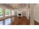 Open concept living room with fireplace, hardwood floors, and large windows at 10765 Shallowford Rd, Roswell, GA 30075