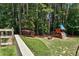 The backyard of this house has mature trees and a playset at 1120 Bentwater Dr, Acworth, GA 30101