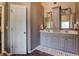 Bathroom featuring double vanities, framed mirrors, and elegant lighting fixtures at 1120 Bentwater Dr, Acworth, GA 30101