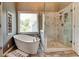 Bathroom with soaking tub, glass shower, and a window, creating a serene and luxurious space at 1120 Bentwater Dr, Acworth, GA 30101