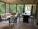 Covered porch with wooded backyard views, comfortable seating and dining area with ceiling lights at 1120 Bentwater Dr, Acworth, GA 30101