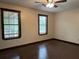 This bedroom features two windows with blinds, hard floors, a ceiling fan and neutral walls at 1253 Todiway Ct, Jonesboro, GA 30238