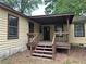 Back exterior of a yellow house with stairs leading up to a covered porch at 1253 Todiway Ct, Jonesboro, GA 30238