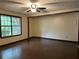 Open living space features hardwood flooring, a ceiling fan, and a large window bringing in natural light at 1253 Todiway Ct, Jonesboro, GA 30238