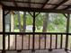 Covered back porch with wood railing overlooking a backyard with mature trees and a storage shed at 1253 Todiway Ct, Jonesboro, GA 30238