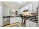 Bright kitchen boasts white cabinets, stainless steel appliances, and stone countertops at 4216 Stillwater Dr, Duluth, GA 30096