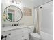 Bright bathroom boasts a white vanity, round mirror, and a shower-tub combination at 710 Crab Orchard Ct, Roswell, GA 30076