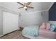 Bright bedroom features a ceiling fan, light gray walls, white trim, and closet doors at 710 Crab Orchard Ct, Roswell, GA 30076