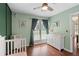 Charming Bedroom featuring mint-colored walls, hardwood floors, and natural light, a beautiful space for baby at 710 Crab Orchard Ct, Roswell, GA 30076