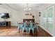 Bright dining room with wood floors, modern light fixture, and double doors to the exterior at 710 Crab Orchard Ct, Roswell, GA 30076