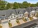 An aerial view of townhomes with multi-car garages, manicured landscaping and tree lined streets at 1070 Harper Dr, Alpharetta, GA 30076