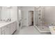 Bathroom featuring double vanity, glass shower, and luxurious soaking tub at 1070 Harper Dr, Alpharetta, GA 30076