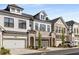 Attractive townhomes with brick and siding, featuring garages and manicured landscaping at 1070 Harper Dr, Alpharetta, GA 30076