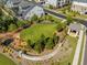 Aerial view of community greenspace, featuring a large lawn and entrance sign amidst trees and landscaping at 1070 Harper Dr, Alpharetta, GA 30076