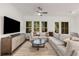 Sun-drenched living room featuring a modern sectional sofa, decorative pillows, and a stylish ceiling fan at 1070 Harper Dr, Alpharetta, GA 30076