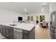 Open concept kitchen, living, and dining space with stainless appliances and lots of natural light at 1070 Harper Dr, Alpharetta, GA 30076