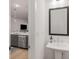 A view into the living area past a stylish sink and mirror in the powder room at 1070 Harper Dr, Alpharetta, GA 30076
