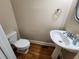 Cozy half bathroom with pedestal sink and warm-toned wall at 10856 Ellicot Way, Alpharetta, GA 30022