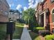 Landscaped walkway between townhomes with manicured hedges, lush grass, and a community mailbox at 10856 Ellicot Way, Alpharetta, GA 30022
