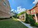 Well-maintained landscaping and walkways between brick townhomes in a peaceful community setting at 10856 Ellicot Way, Alpharetta, GA 30022